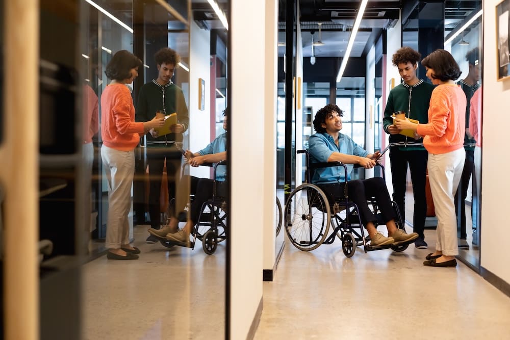 People discussing in a modern office hallway.