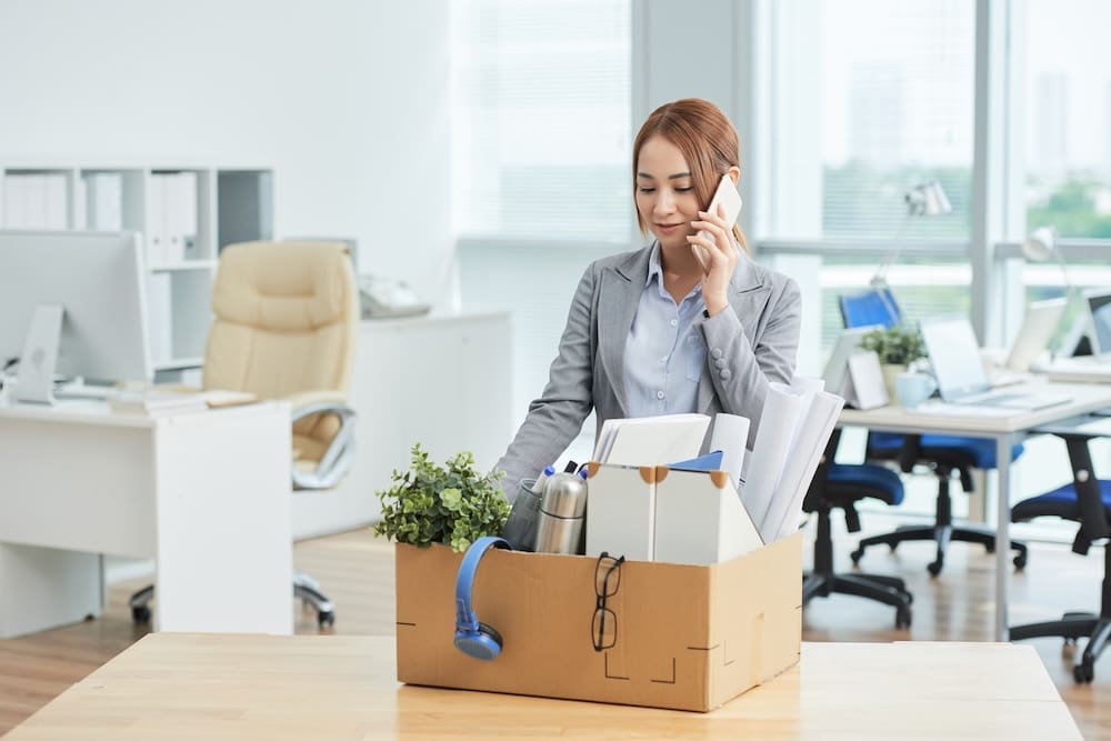 a businesswomen packing her office belongings after getting fired