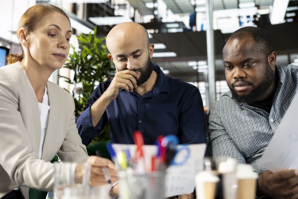 Three coworkers reviewing documents in office