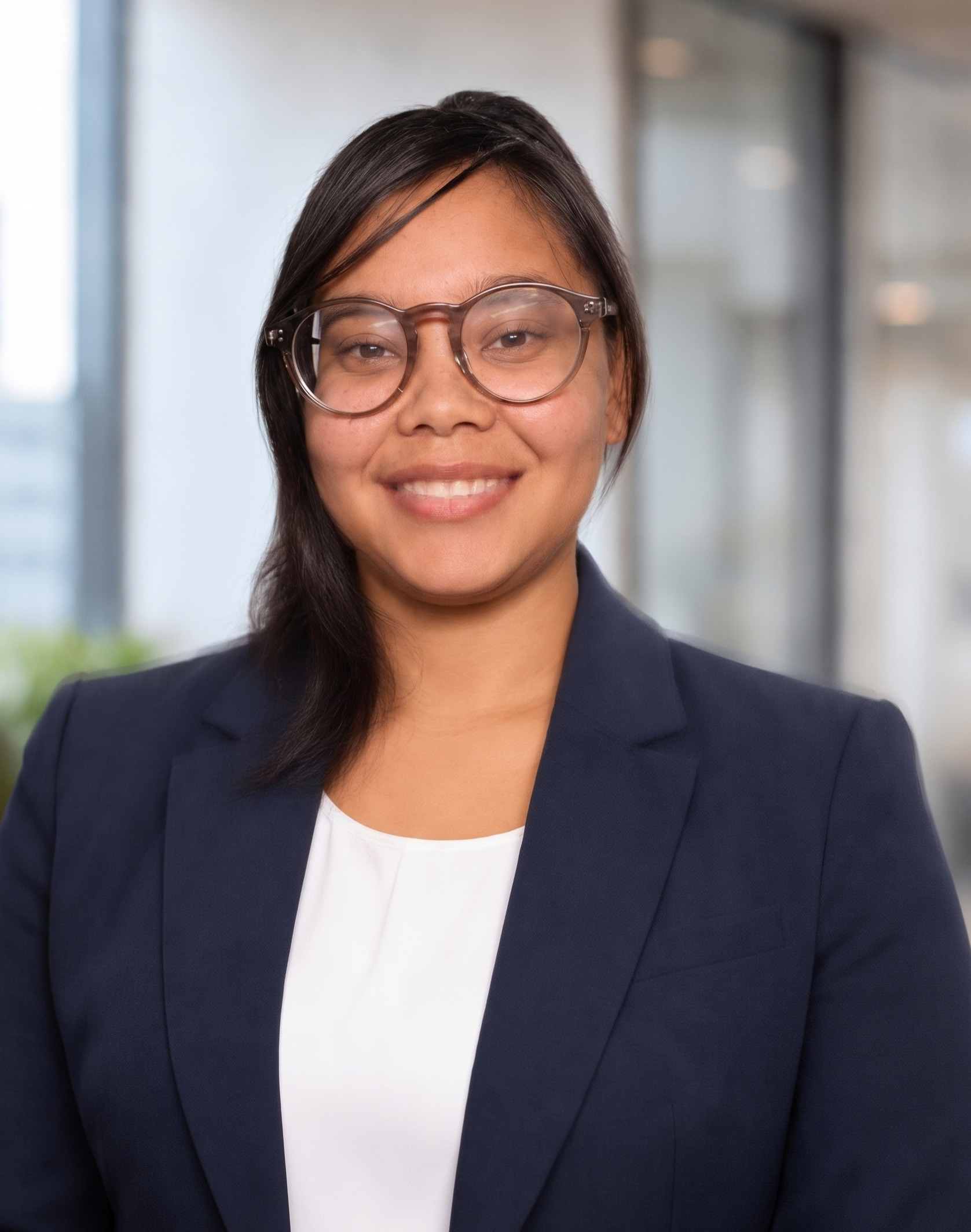A photo of a woman wearing glasses, a white shirt, and navy blazer.