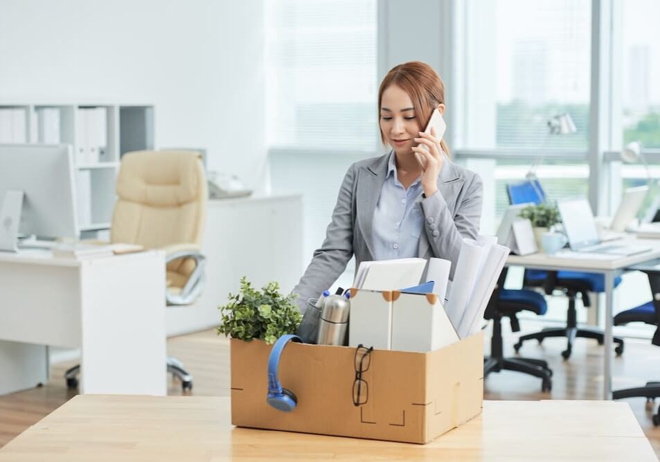 a businesswomen packing her office belongings after getting fired