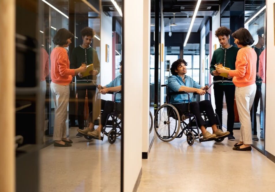 People discussing in a modern office hallway.