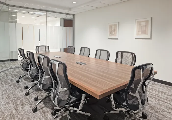 Modern conference room with large wooden table.