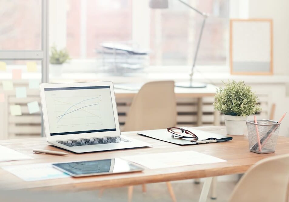 Modern office desk with laptop and supplies.