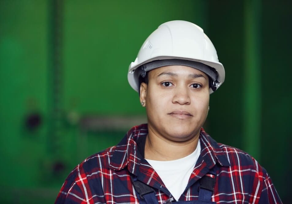Person wearing hard hat and plaid shirt.