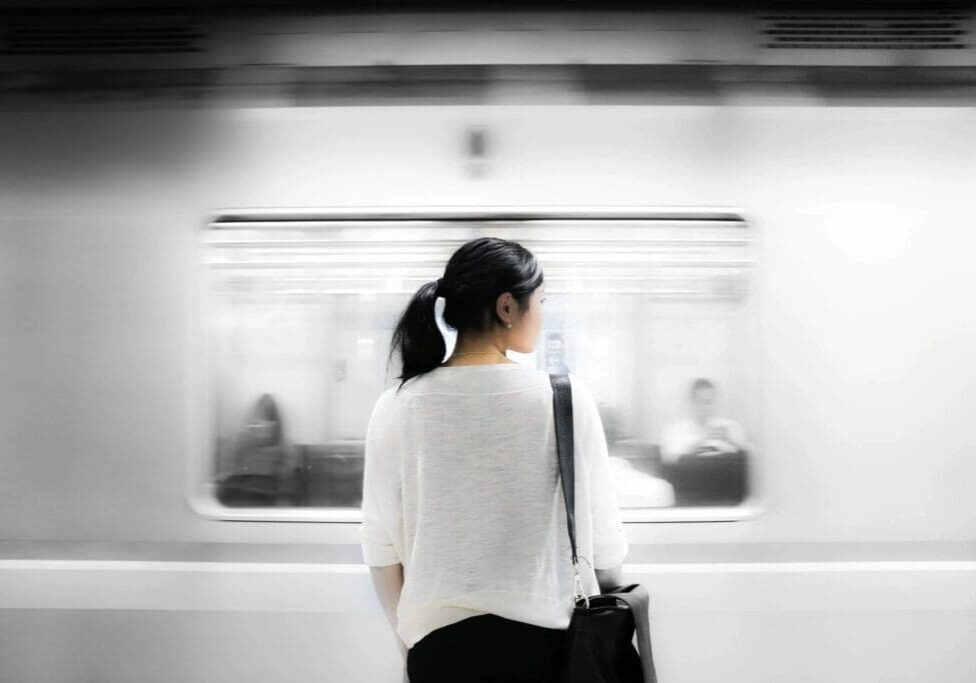 Woman standing in front of moving train.