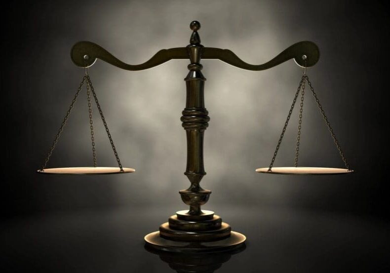 Scales of justice against dark background.