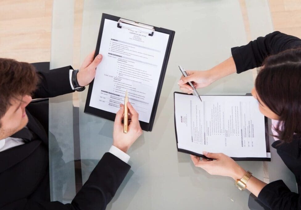 Two people reviewing documents at table.