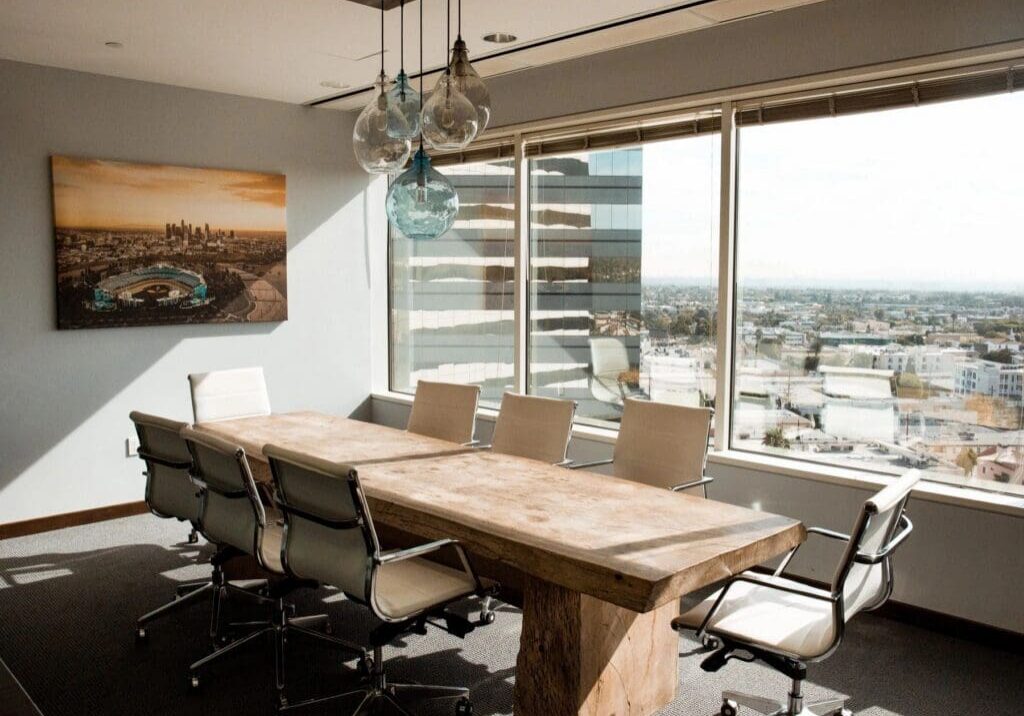 Sunlit conference room with wooden table, city view