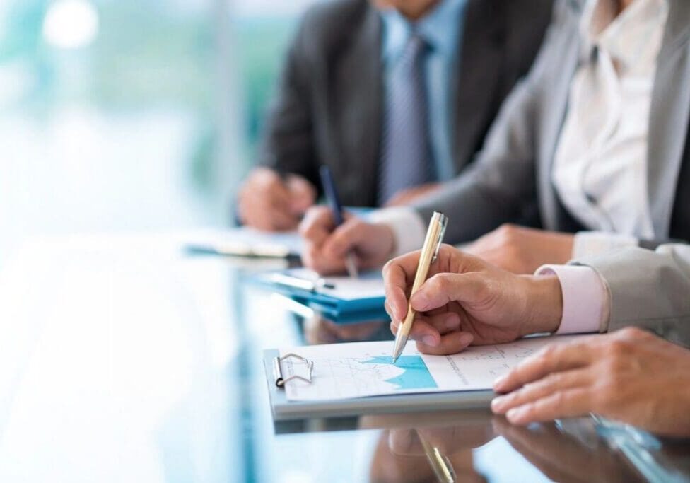 Business professionals taking notes on financial charts