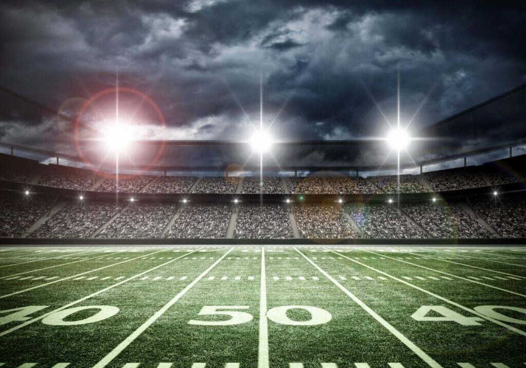 Football stadium under bright night lights.