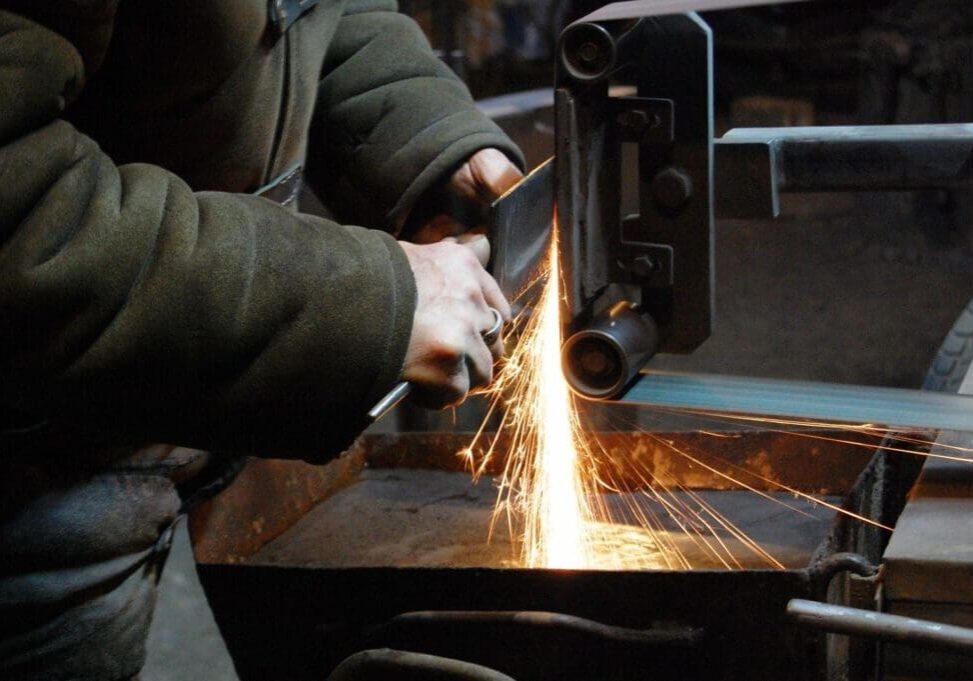 Person sharpening knife on grinding wheel.